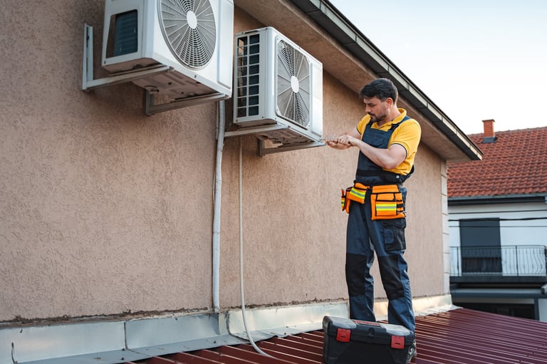 HVAC technician is installing an air conditioner on the wall of a house